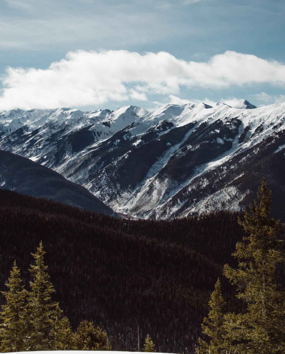 snowy mountains with cloudy skies during daytime
