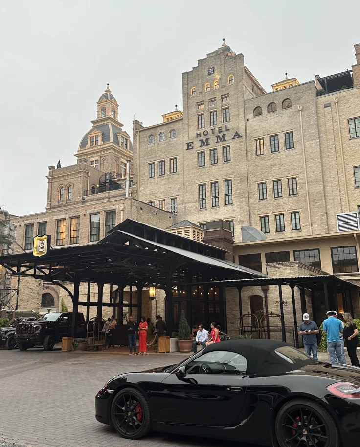 The entrance to the Hotel Emma Building, an ornate tan, stone, multi-level building with a large covered, drive-up entrance.