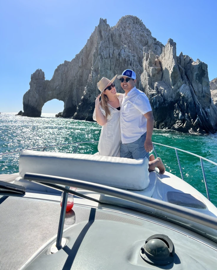 Travel advisor Alyssa and partner on boat in front of the Arch of Cabo San Lucas