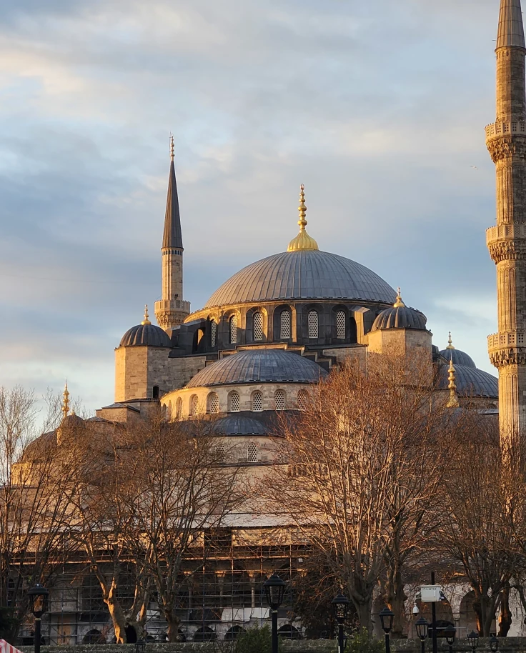 The outside of a large mosque building during the daytime