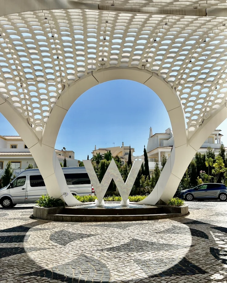 The entrance of the W hotel with a large white structure and a large white 'W' sign.