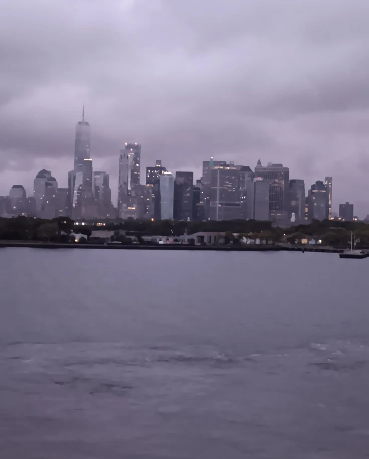 A view of a city skyline from the water during a cloudy day