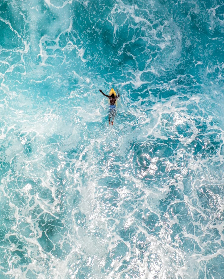 A person in water with surfboard.