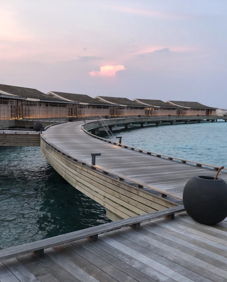 wooden overwater pathway leading to various bungalows