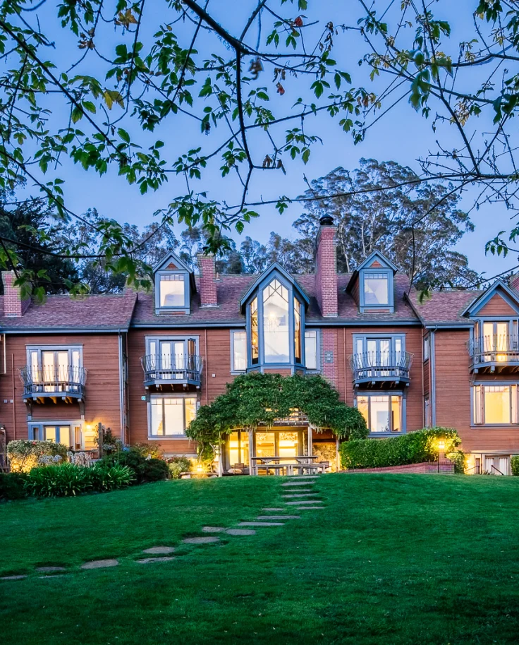 The exterior of a large house lit up at nighttime