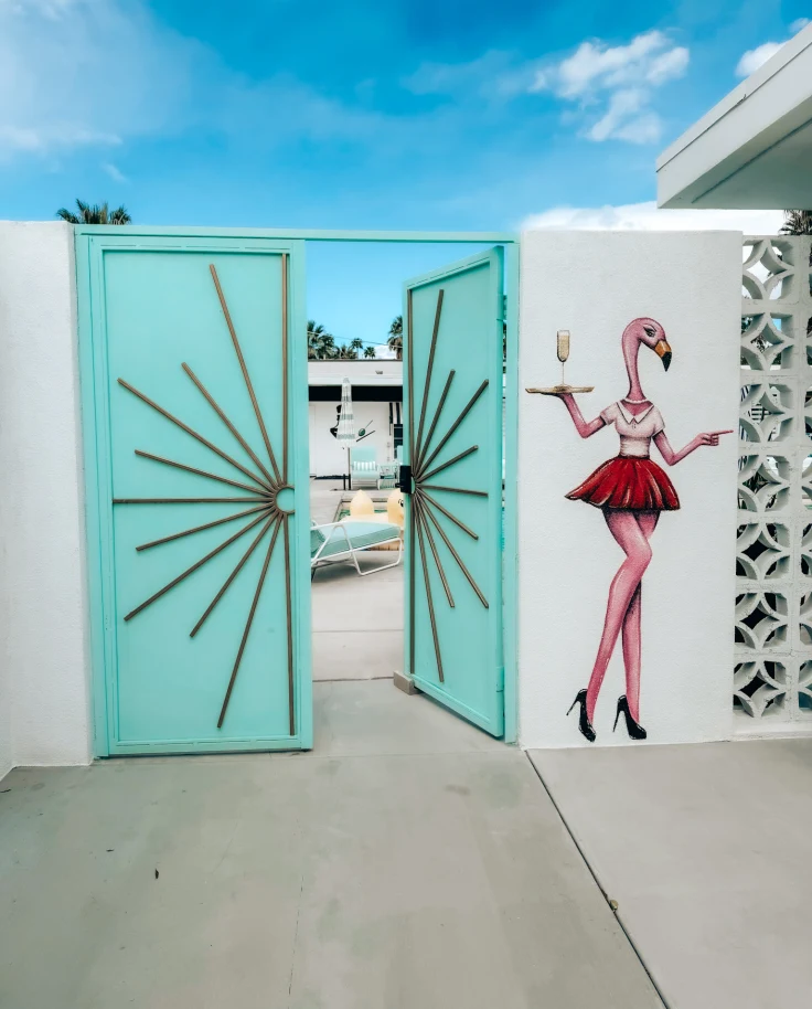 A teal outside door leading to a pool area during the daytime
