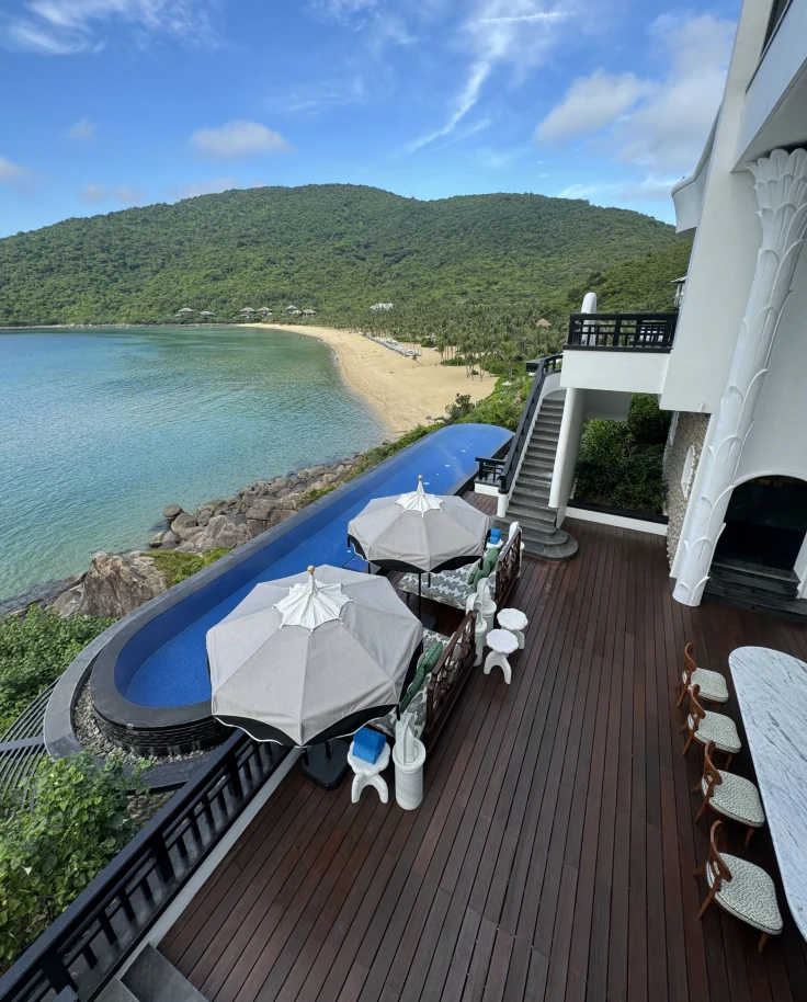 The hotel patio with two umbrellas and pool overlooking the ocean.