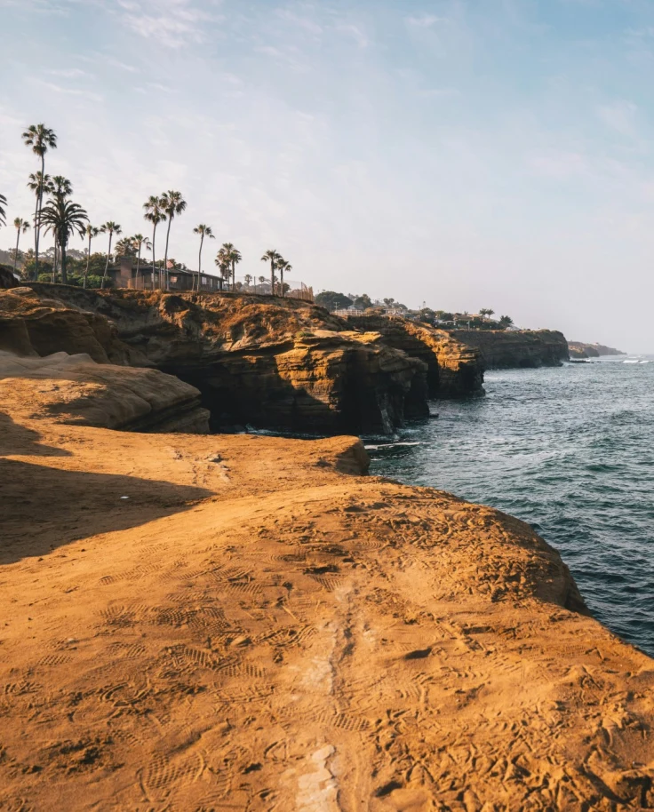 Rocky cliffs, palm trees and the blue sea view.