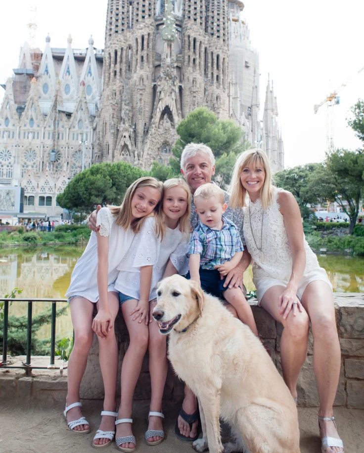 A view of Jill, a man, three kids and a dog posing in front of a popular tourist attraction in Barcelona, Spain.