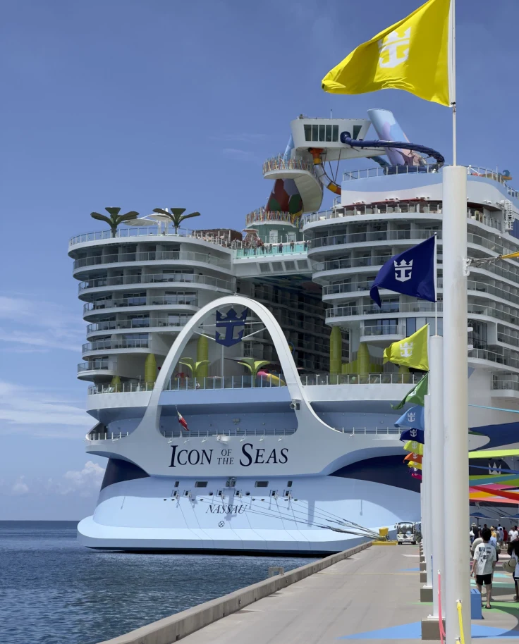 Royal Caribbean's Icon of the Seas docked in the harbor on a sunny day.