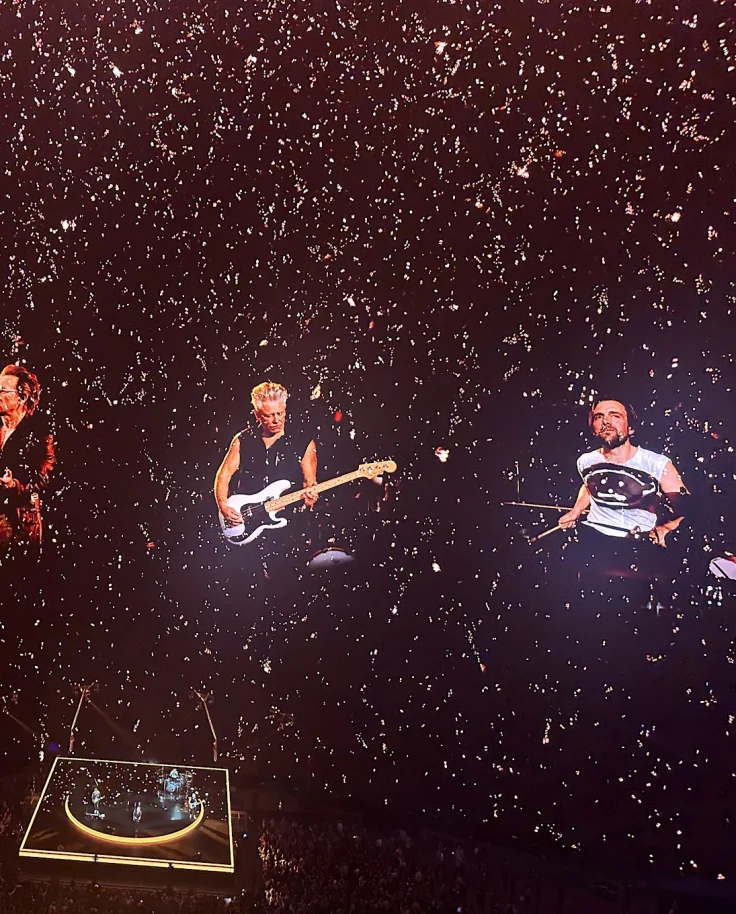 A view of U2 performing in Las Vegas against a starry black background