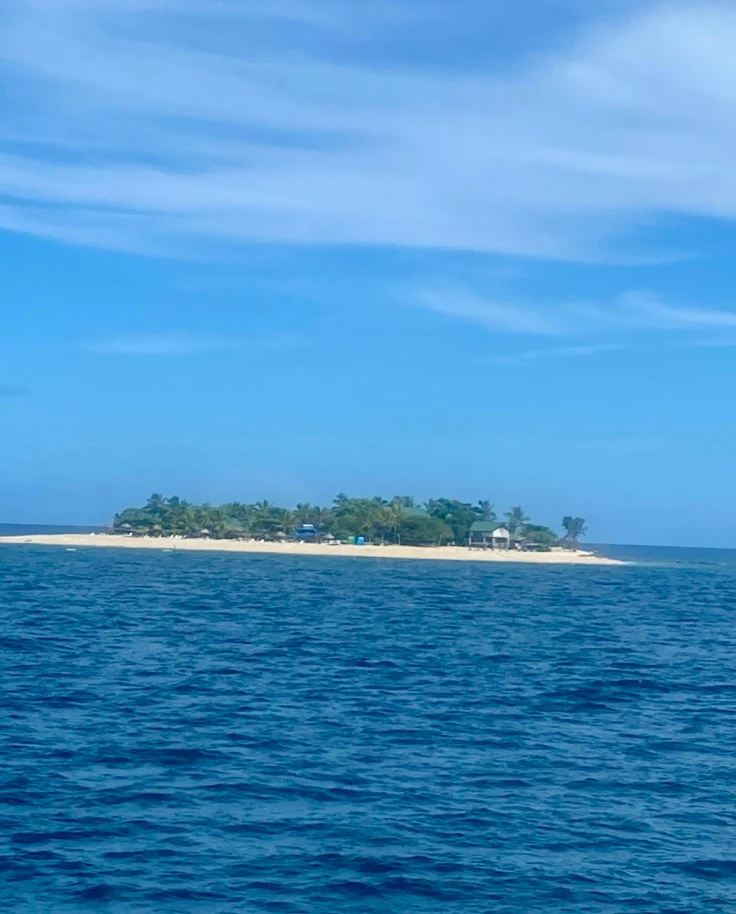 Blue ocean and blue sky with an island in the distance.