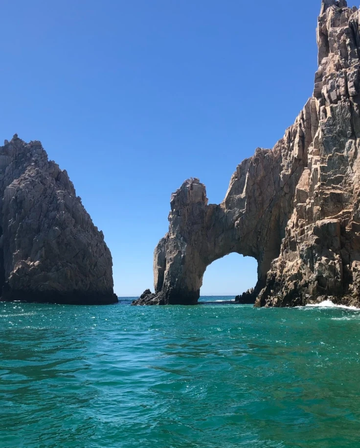 Large rock formations next to the cliffside in the water