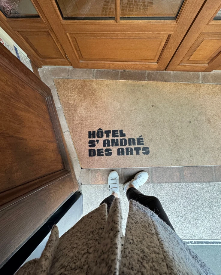 A photo of the entrance to St Andre Des Arts, one of the best hotels in St. Germain Paris, from above looking down at the entry mat.