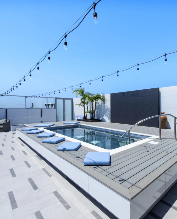A hotel's rooftop pool, under a clear, blue sky.