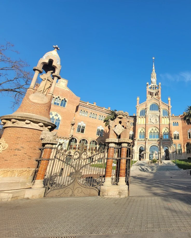 A low-angled photo of a large, orange cathedral-like building