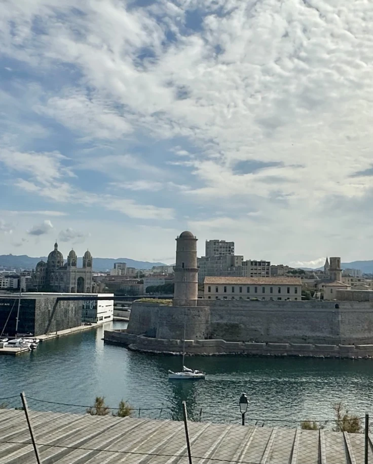 A city with water around it is seen from a distance.