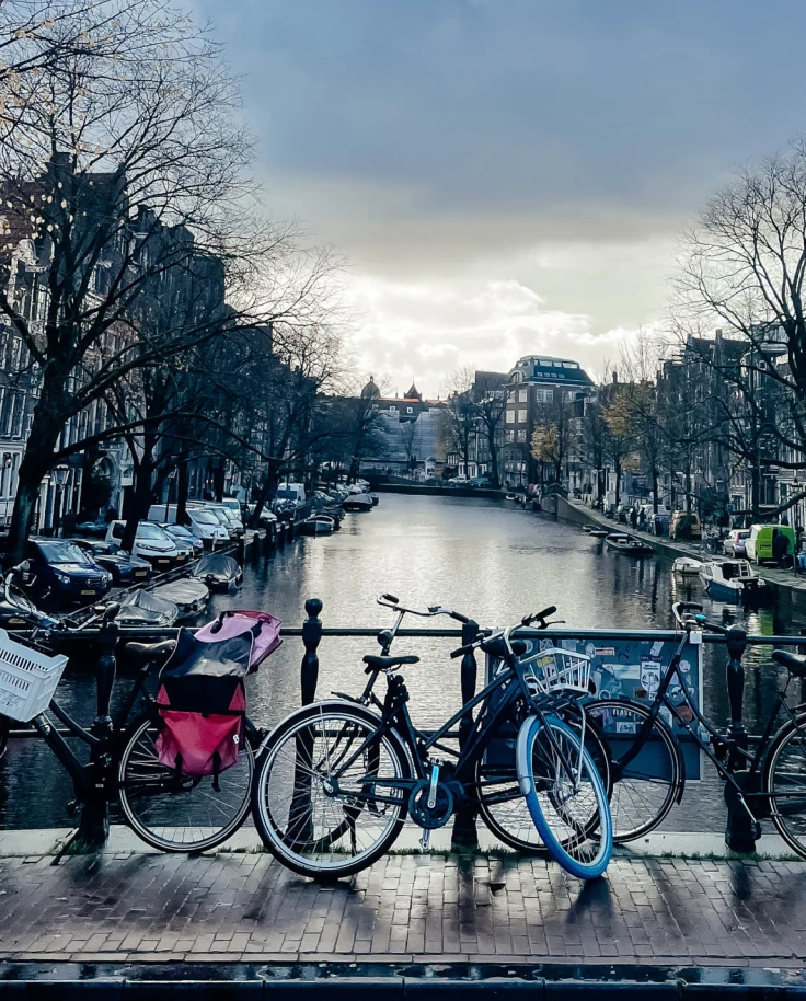 Canal and canal side view with bicycles and a beautiful view of Amsterdam architecture.