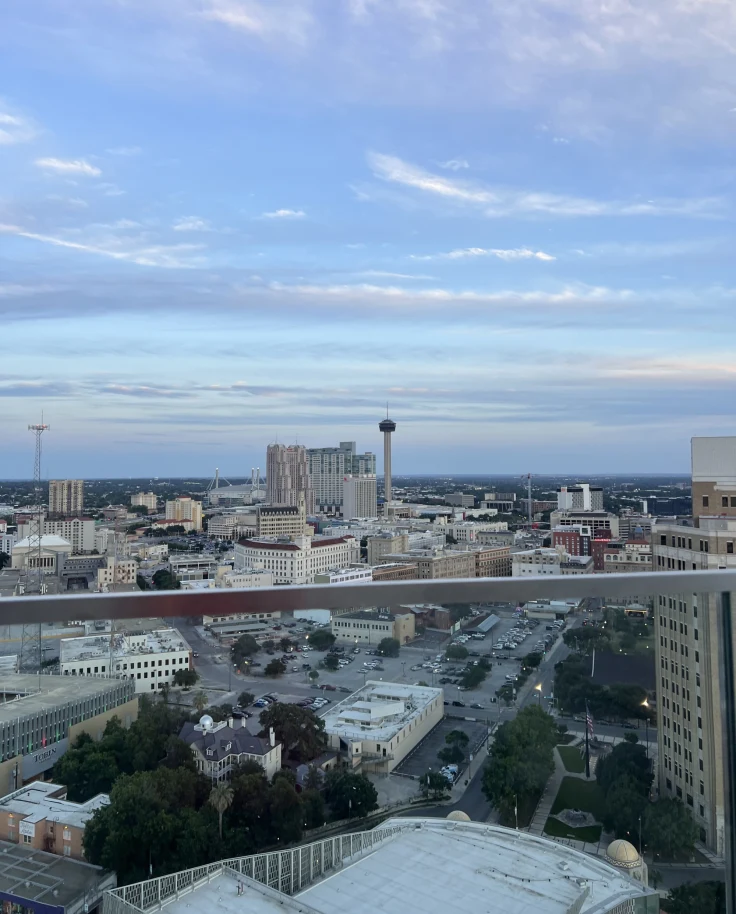 View of city buildings from a rooftop patio during the evening