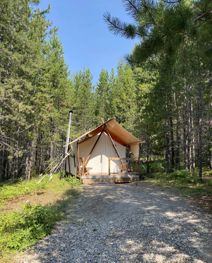 A tent in the woods during the daytime