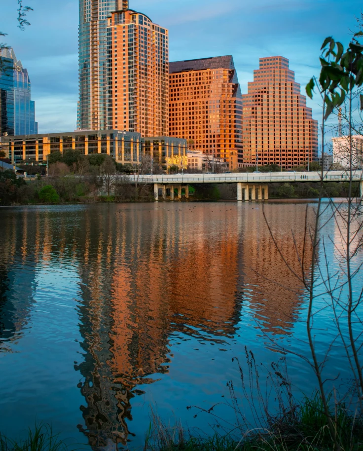 Lakeside front in Austin, Texas with orange sunset hues on the downtown buildings.