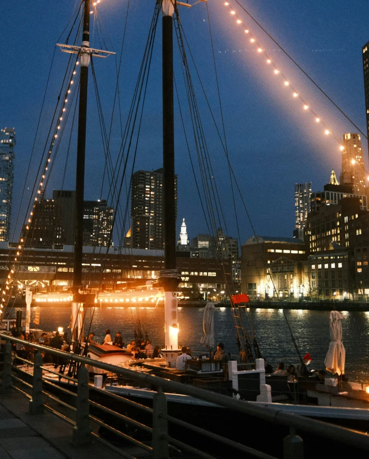 A boat in the water lit up at nighttime