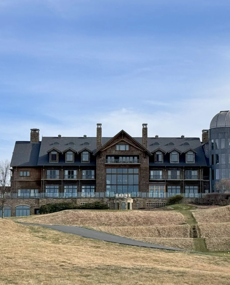 A picture of Primland Resort, a large brick building, set on a hill with grassy grounds.