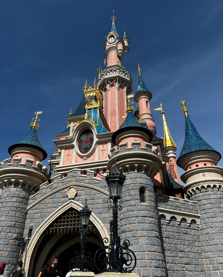 A ground view of the Disneyland Paris castle amid a clear, cloudless sky.