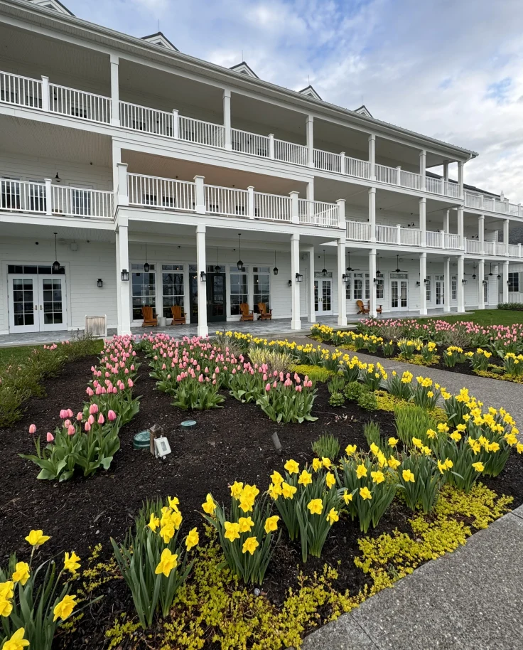 The exterior of the lake house, a white building with balconies and flowers out front  - Noelle Rudloff