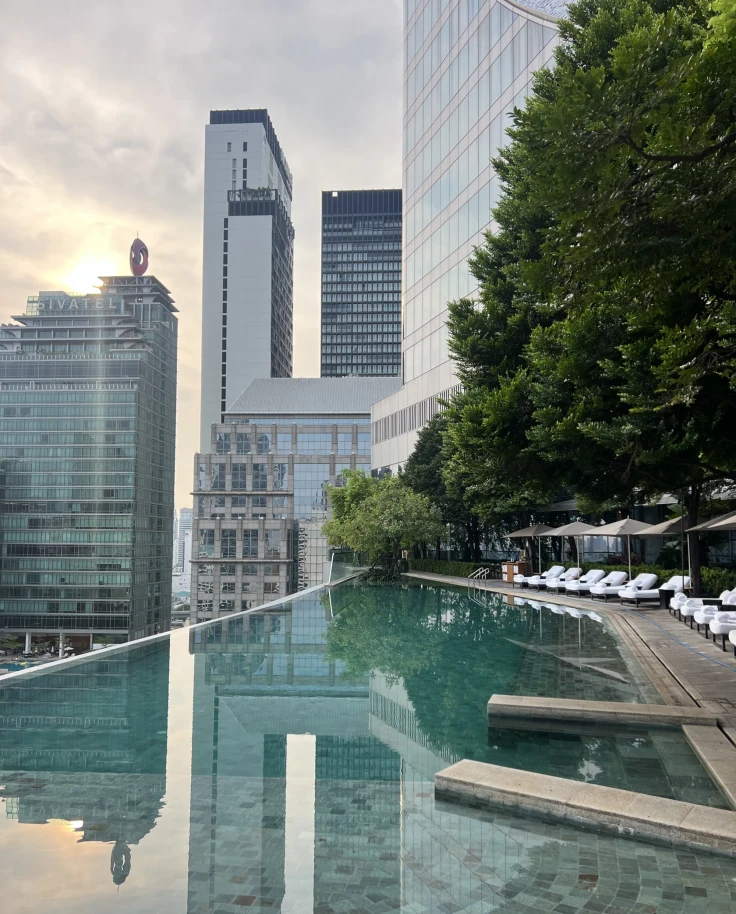 Park Hyatt Bangkok Pool surrounded by sky scraper buildings at sunset- Emily Martin
