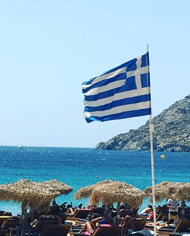 A view of the ocean with the Greek flag flying in the wind
