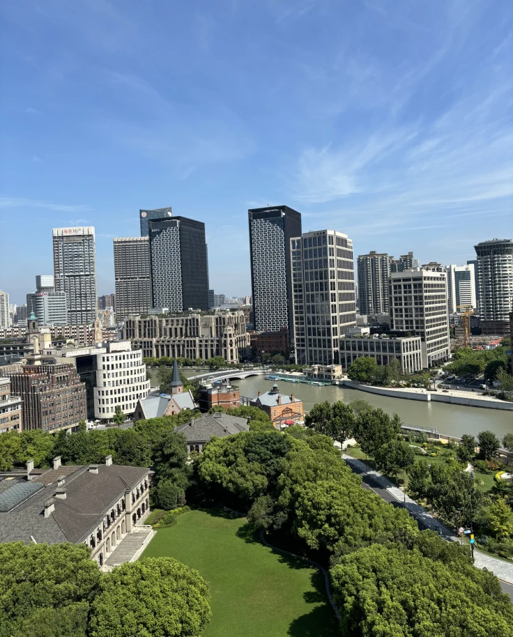 An aerial view of a city skyline next to a grass field during the daytime