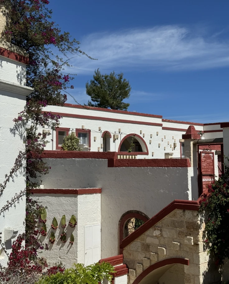 A view of a white stucco and charming villa on a sunny day in Masseria, Italy.