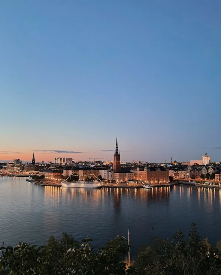 A view of a city next to a body of water at dusk.