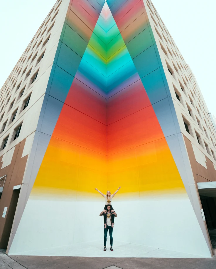 Couple standing in front of street art in Texas.