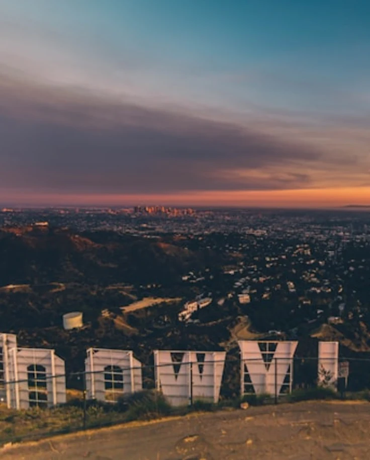 Aerial view of a city behind the famous Hollywood sign