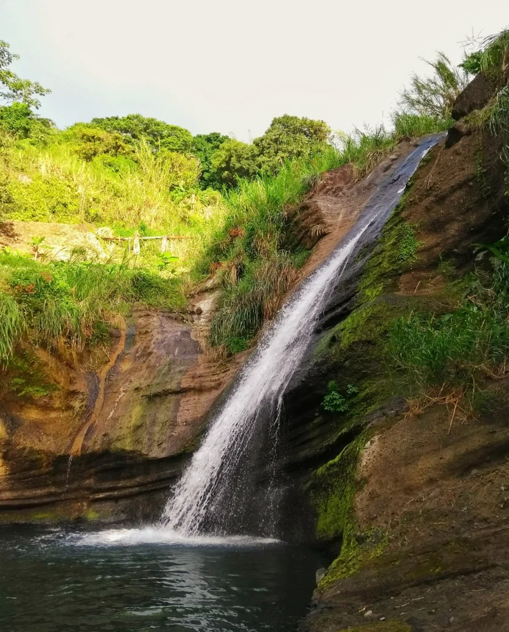A small stream waterfall rushing down a cliff.