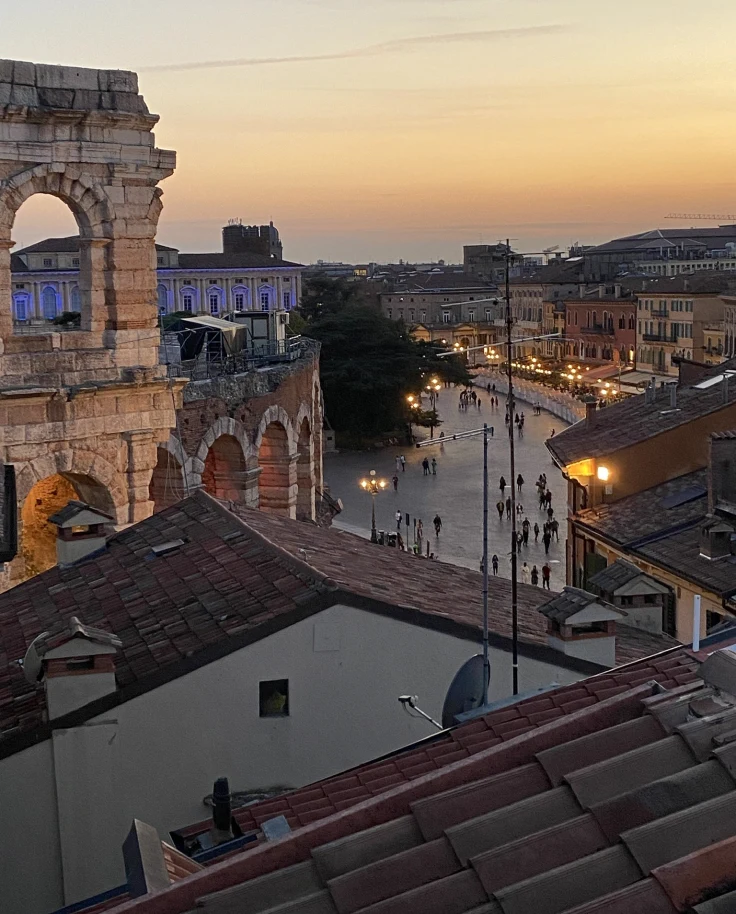 An aerial view of the city with tall tower in the middle of the city during sunset.
