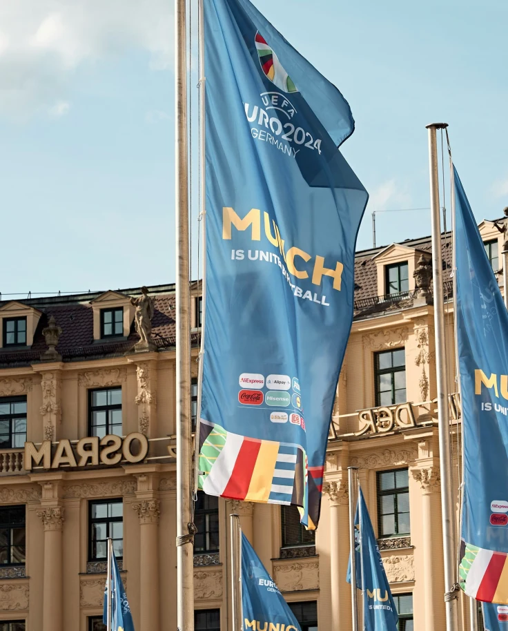 A bunch of flags in front of a building.