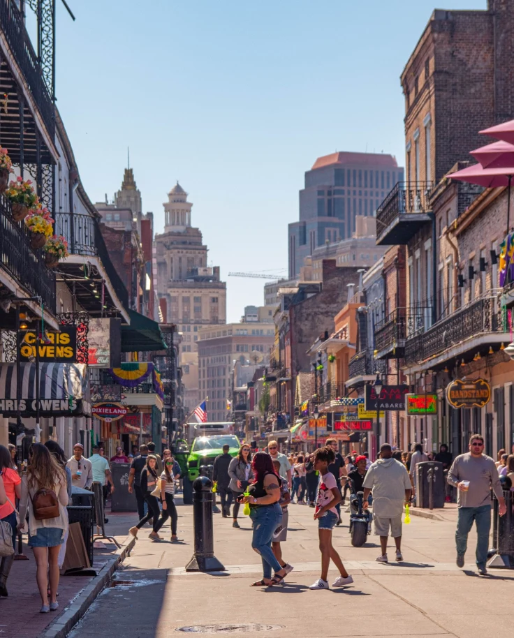 People walking on a street surrounded by shops and cafes.