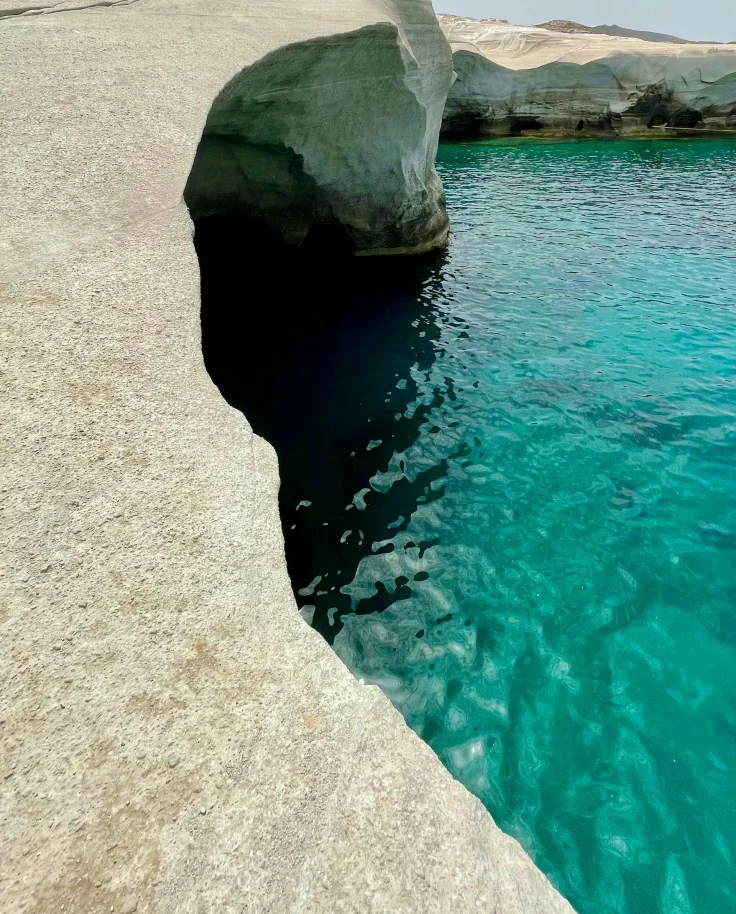 White rock formation next to blue water during the daytime