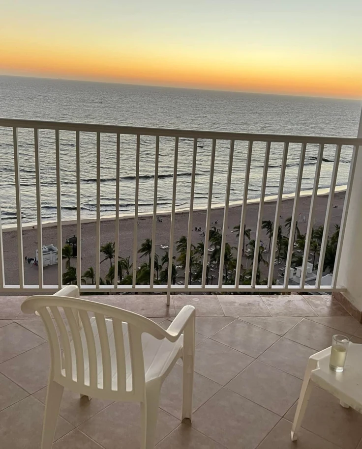 A picture of the sunset over the ocean from a white balcony at the Hotel Riu Mazatlan, Mexico.