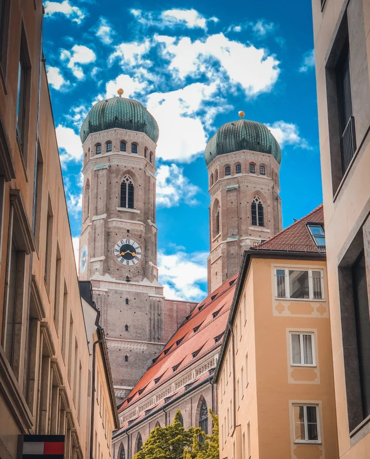 A low angle shot of two green and brown buildings