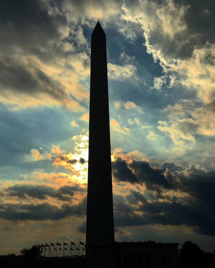 Silhouette of a tall tower against a sunset sky