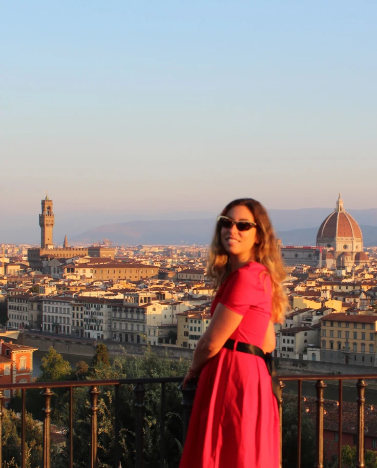 Advisor standing on a balcony with Florence skyline in the background.