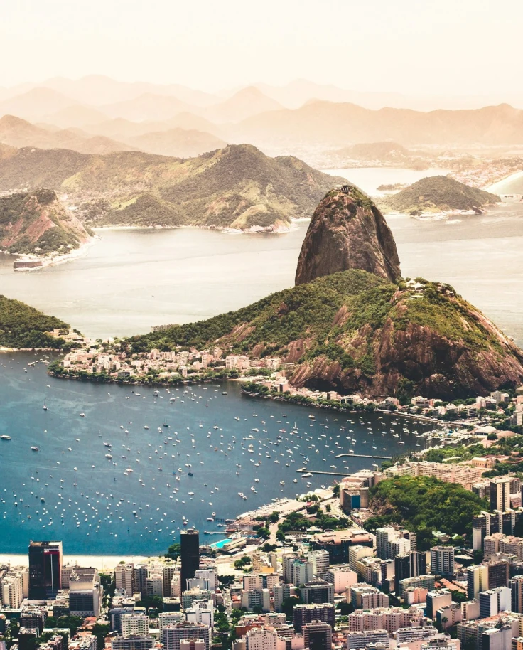 A view of Rio from above with buildings and mountains with water on either side.