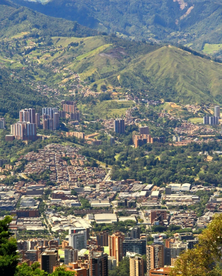 city surrounded by large green mountains