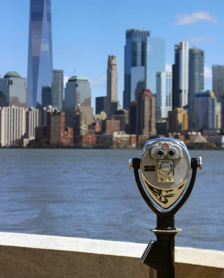 New York Manhattan from a distance with a coin-operated binocular machine at the forefront.
