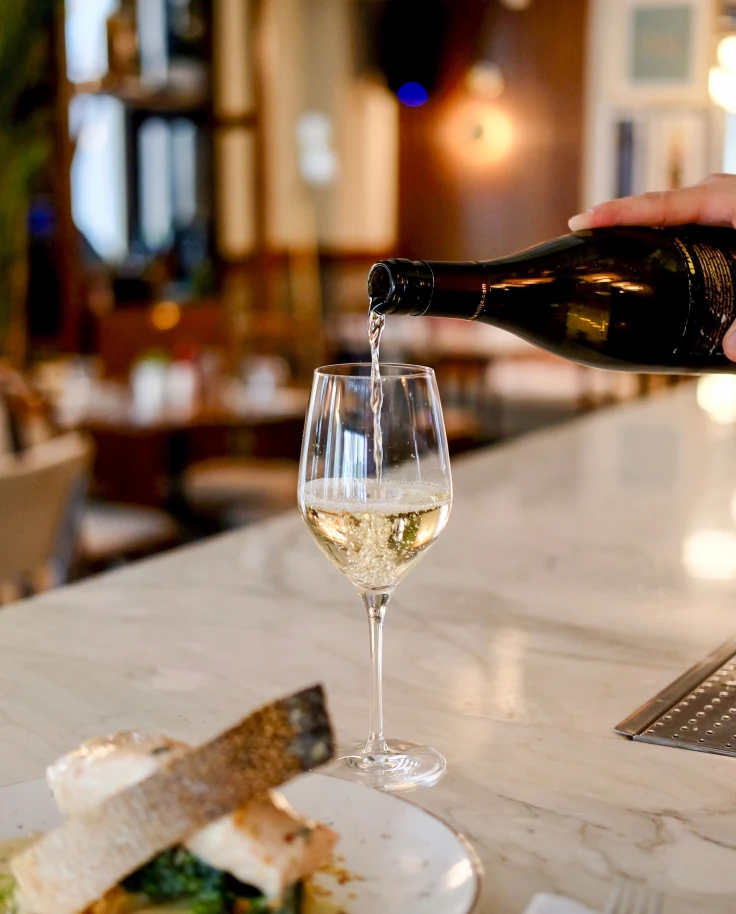 white wine being poured into class