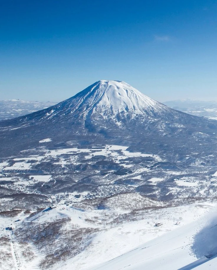 People hiking with skis on snow-covered mountain during daytime